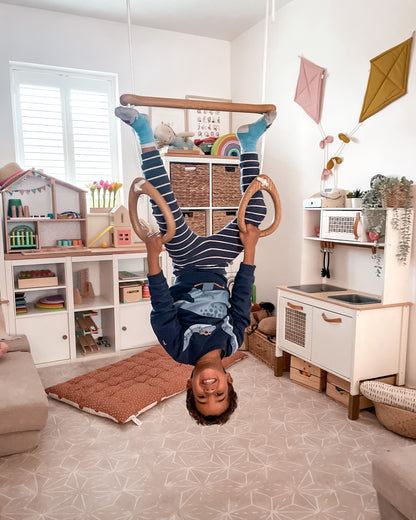 Child playing with wooden climbing toy in a playroom